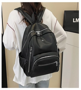 Close-up of the black pebbled leather backpack showing the padded straps and back panel