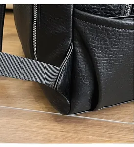 Detail of triangular reinforced stitching on lychee texture leather backpack strap