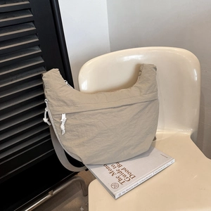 Light khaki nylon crescent crossbody bag with adjustable wide strap and zip front pocket