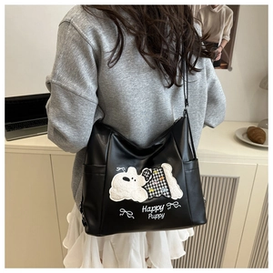 Detail of black large tote bag featuring cute plush puppy embroidery and Happy Puppy text
