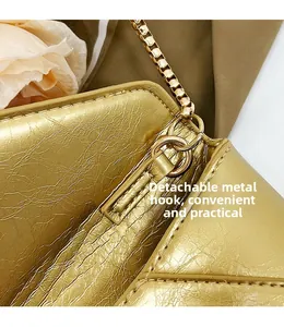 Detail of the golden metal hook and detachable chain strap on the textured leather bag