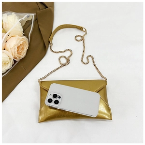 Detailed size comparison of the gold metallic chain envelope bag with a smartphone