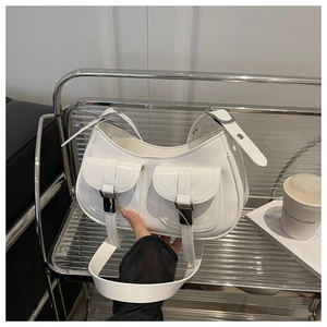 Detailed shot of white glossy underarm bag with double front pockets and silver buckles