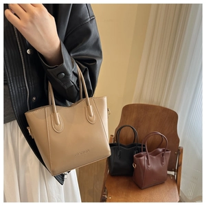 Detail view of large tote bags in khaki, black, and brown with embossed FASHION lettering