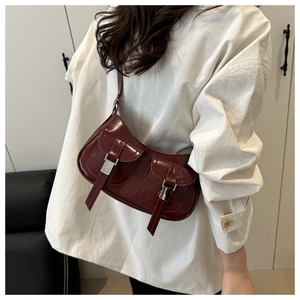 Detail view of wine red retro shoulder bag with glossy finish and silver buckles