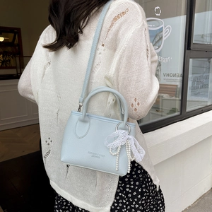 Light blue lychee pattern handbag with lace bow and pearl charm for crossbody wear