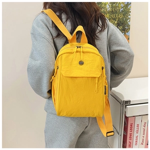 Side view of a yellow nylon backpack with adjustable straps and multiple pockets
