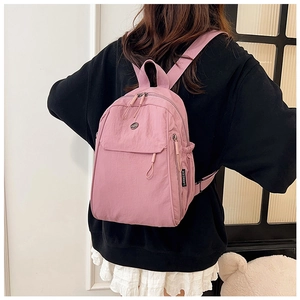 Pink purple travel backpack with main compartment and front pocket shown on a model