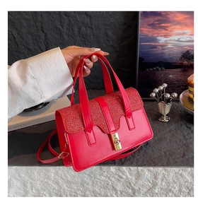 Detail of red sequined flap handbag with gold metal twist lock and dual handles