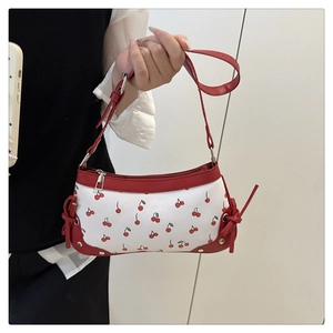Detail of red cherry print shoulder bag with contrast stitching and knot decorations