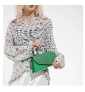 Detail of green mini handbag with sequined flap and silver heart-shaped metal handle