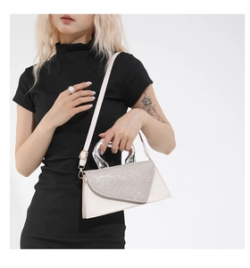 Close-up of elegant cream leather handbag with sparkling rhinestone flap and silver handle