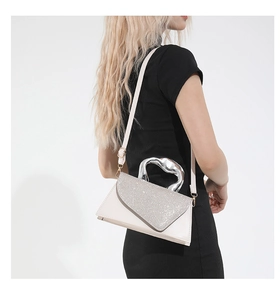 Detail of white leather shoulder bag with sequined flap and silver metallic handle