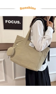 Detail of khaki nylon tote bag with small round coin purse attachment and woven label