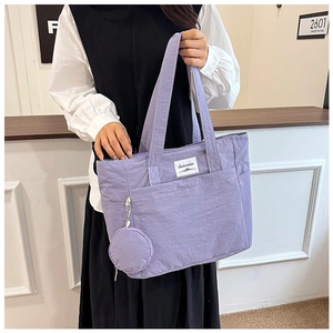 Detail of purple nylon tote bag with small matching round coin purse and white woven label