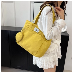Yellow large capacity nylon tote bag with small coin pouch shown on a shoulder