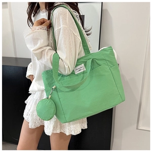 Light green large nylon tote bag with wide strap and matching round coin purse detail