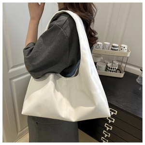 Detail view of large white glossy PU leather shoulder bag with a natural draped design