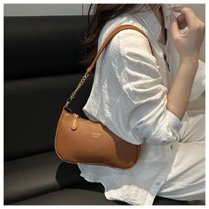Brown lychee leather shoulder bag with gold chain strap worn by a female model