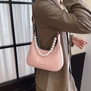 Pink leather hobo bag with luxury pearl handle and gold hardware on model