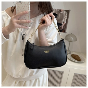 Detail of black crescent hobo bag featuring litchi texture and gold metal chain strap