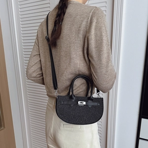 Sparkly black semi-circular Kelly bag with silver hardware and adjustable crossbody strap