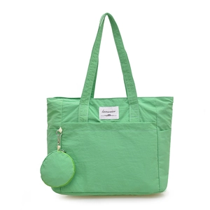 Large light green nylon tote bag with front pocket and round coin purse accessory