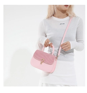 Primer plano del bolso bandolera de cuero rosa con lentejuelas y cierre dorado