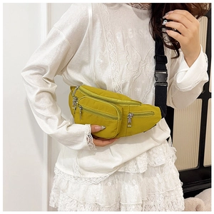 Detail of yellow nylon chest bag with multiple zipper pockets and adjustable black strap