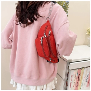 Rear view of red nylon chest bag with metal chain strap worn over a pink hoodie