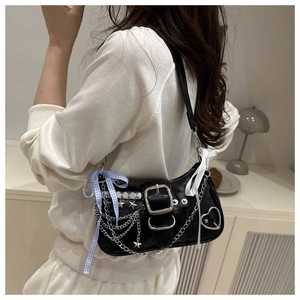 Black matte Y2K shoulder bag with metal chains, star rivets and ribbon bows on model
