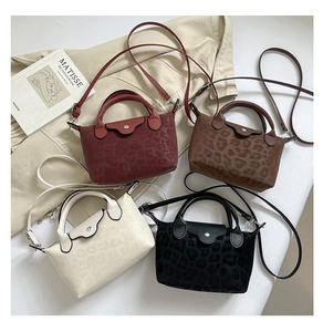 Detalle de cuatro bolsos con estampado de leopardo en rojo oscuro, marrón, beige y negro