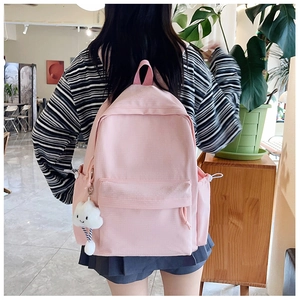 Detail eines hellrosa Rucksacks mit Kordelzugtasche und flauschigem Wolken-Anhänger