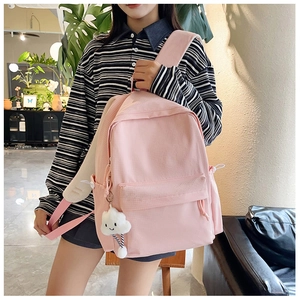Detailansicht eines rosa Canvas-Rucksacks mit einem weißen Plüsch-Wolkenanhänger