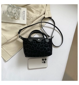 Detalle macro de bolso de leopardo negro con smartphone para comparar el tamaño