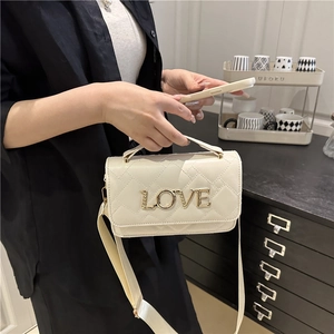Quilted cream crossbody bag with gold LOVE hardware and wide adjustable strap