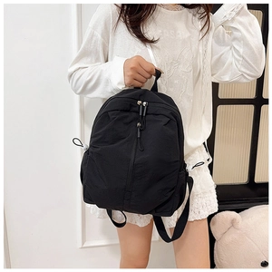 Detail of black nylon backpack with durable dual zippers and side drawstring pockets
