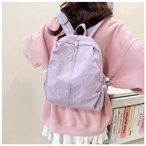 Close-up of lightweight lilac purple nylon backpack featuring pleated texture and side drawstrings