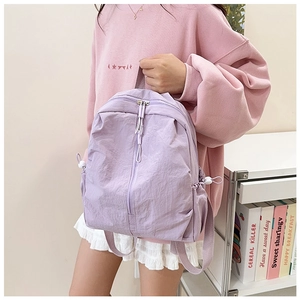 Detailed view of lightweight purple nylon backpack with vertical zipper and side drawstrings