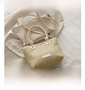 Detail of straw woven tote bag with adjustable strap and smartphone size comparison