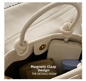 Detail of the magnetic closure and knot design on this cream straw bucket bag interior