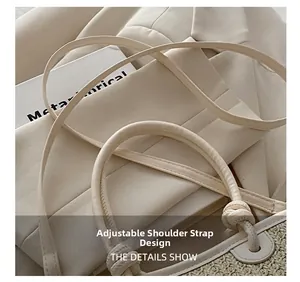 Detail showing the adjustable knot shoulder strap on the beige woven straw bucket bag
