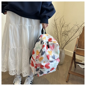 Détail d'un sac à dos en toile avec graffiti de cœurs colorés sur un fond lifestyle