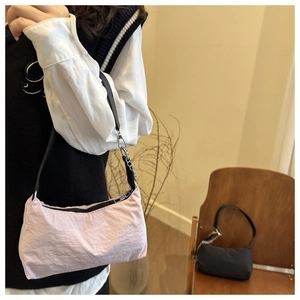 Detail of pink nylon shoulder bag with silver chain strap and pleated texture finish