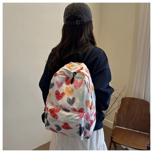 Rear view of casual white backpack with colorful heart graffiti on a model back