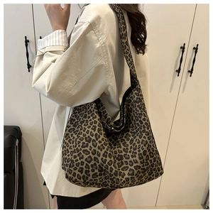 Detail of large leopard print canvas tote bag showing the texture and pattern on model