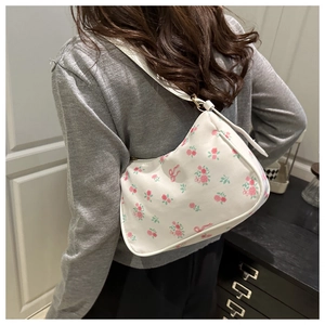 Detailed side view of white floral shoulder bag featuring pink roses and bow patterns