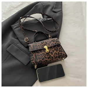 Détail du sac bandoulière léopard avec boucle en métal doré et poignée noire