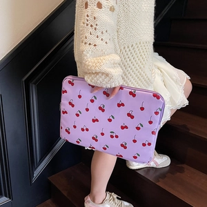Chic lavender laptop sleeve with red cherry pattern carried by a model on stairs