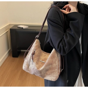 Brown suede hobo tote bag featuring a metallic fashion logo and slim shoulder straps